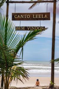 a person sitting on the beach next to the ocean at Canto Leela Eco Bungalows in Serra Grande