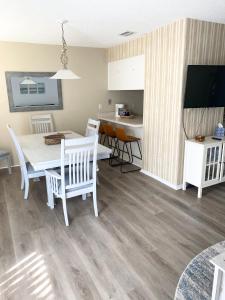 a kitchen and dining room with a table and a television at Beachfront Serenity Private Balcony with Ocean View, Shared Heated Pool and BBQ in New Smyrna Beach