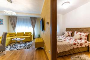 a bedroom with a bed and a living room at Apartman Grand Zlatibor in Zlatibor
