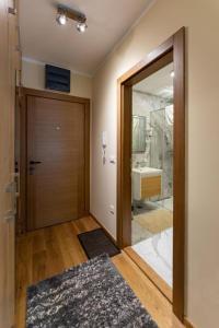 a bathroom with a door and a bathroom with a sink at Apartman Grand Zlatibor in Zlatibor