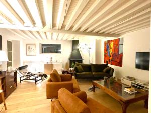 ein Wohnzimmer mit einem Sofa und einem Tisch in der Unterkunft Chambre calme Ouest Lyonnais in Lentilly