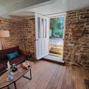 a living room with a door open to a patio at Tourellerenard in Bussières-lès-Belmont