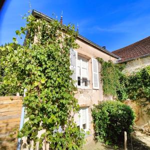 an ivy covered building with a house at Tourellerenard in Bussières-lès-Belmont