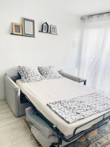 łóżko szpitalne w pokoju z oknem w obiekcie Cosy appart proche Paris w mieście Saint-Denis