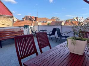 a balcony with two benches and a table and chairs at Boutique Apartments Oradea in Oradea