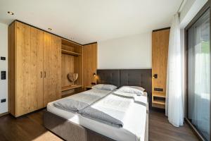 een slaapkamer met een groot bed en houten kasten bij Sunnseitn Lodge Exclusive Panorama in Stulles