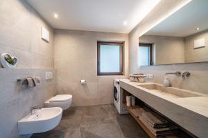 een badkamer met een wastafel, een toilet en een spiegel bij Sunnseitn Lodge Exclusive Panorama in Stulles