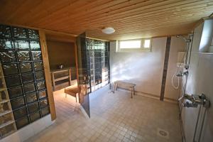 a bathroom with a shower with a bench and a window at Overkalix Holiday Home with Sauna in Jock
