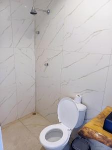 uma casa de banho branca com um WC e um chuveiro em Cantinho da Praia do Meio em São José de Ribamar