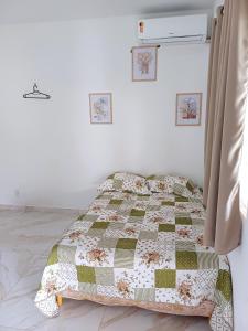 um quarto com uma cama com uma colcha em Cantinho da Praia do Meio em São José de Ribamar