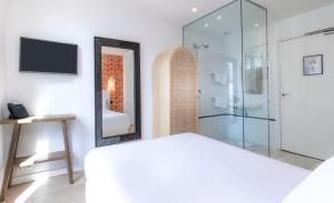 a bedroom with a white bed and a mirror at Hôtel Emile Le Marais in Paris