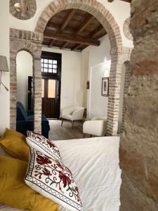 1 dormitorio con 1 cama con arco de piedra en Llana 5 alojamiento turistico, en Jaén