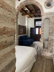 sala de estar con cama y sofá azul en Llana 5 alojamiento turistico, en Jaén