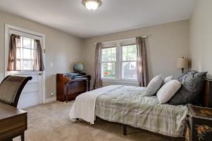 1 dormitorio con 1 cama, escritorio y ventanas en Family-Friendly Fortville Rental Home with Fire Pit!, en Fortville