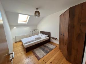 a bedroom with a bed and a large wooden door at Qendresa Apartments in Prishtinë
