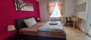 a bedroom with a bed with a pink wall at Edel Apartments Dulliken in Dulliken