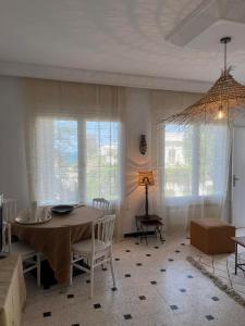 a dining room with a table and chairs and windows at Luxeux et Idéal à Marsa Plage vue sur Mer in La Marsa