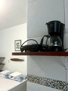a coffee maker on a shelf in a kitchen at Pousada Apart Amor de Jeri in Jericoacoara