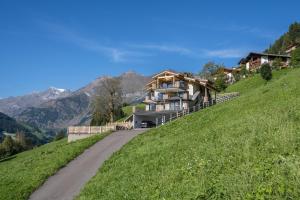 a house on the side of a hill with a road at Sunnseitn Lodge Apt Mountainsuite in Stulles