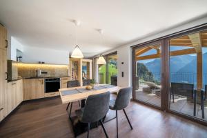 cocina con mesa y sillas y ventana grande en Sunnseitn Lodge Apt Mountainsuite, en Stulles