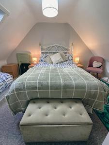 a bedroom with a large bed with a green comforter at South Lochs Cottage in Marvig +63 photos