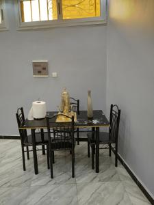 uma mesa de jantar preta e cadeiras num quarto em Residence NOURAH em Rufisque
