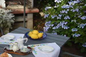 a table with plates and a bowl of lemons on it at L'Oasi delle Vigne in Rome