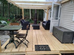 eine Terrasse mit einem Tisch und einem TV auf einer Terrasse in der Unterkunft Chalet met veranda aan bosrand in Vledder