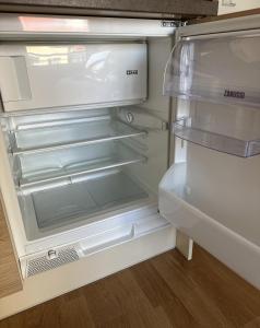 an empty refrigerator with its door open in a kitchen at Nomad Apartments in Prague