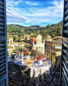 a table on a balcony with a view of a city at La Loggia Sul Nera in Arrone