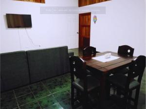 a dining room with a wooden table and chairs at Pura Vida House in Quepos