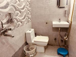a small bathroom with a toilet and a sink at The For You Hotel & Restaurant in Rishīkesh