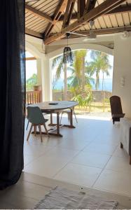 een eetkamer met een tafel en uitzicht op de oceaan bij Villa d’ô in Majikavo Koropa