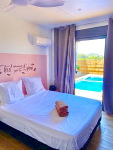 - une chambre avec un lit blanc et une vue sur la piscine dans l'établissement La Villa Horizon, à Rivière du Rempart