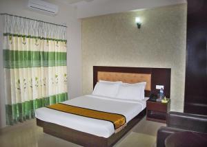 a bedroom with a large bed and a chair at Beach Way in Cox's Bazar