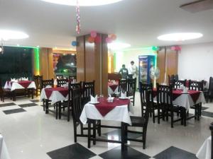 a dining room with red and white tables and chairs at Beach Way in Cox's Bazar