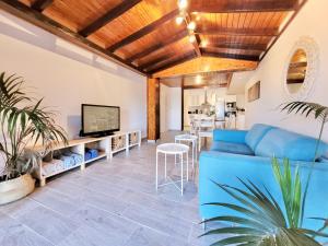 sala de estar con sofá azul y TV en Casa Rural - Playa. Situada en un entorno natural. en La Orotava