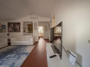 a living room with a white couch and a television at Villa Utilia into the wild in Perugia