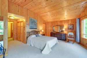 1 dormitorio con 1 cama en una habitación de madera en Tahuya Cabin Hood Canal and Olympic Mountain Views!, en Tahuya