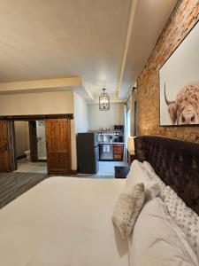 um quarto com uma cama grande e uma parede de tijolos em Eaglescape Suites and Event Center em Miles City