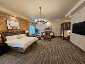 een grote slaapkamer met een bed en een televisie bij Eaglescape Suites and Event Center in Miles City