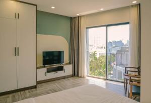 a bedroom with a television and a large window at Anstay Beach Da Nang in Danang