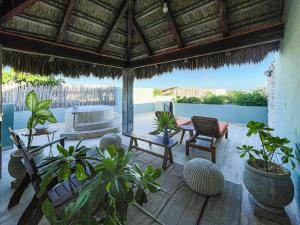 een patio met stoelen en planten en een dak bij Kimpton Aluna Resort Tulum, an IHG Hotel in Tulum