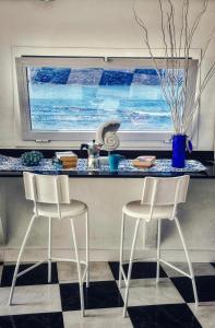 a kitchen with two chairs and a counter with a counter top at Vista Paraiso, Sea breeze facing the sea in La Oliva