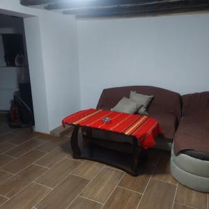 salon z kanapą i czerwonym stołem w obiekcie Guest Rooms Didka w mieście Kopriwsztica