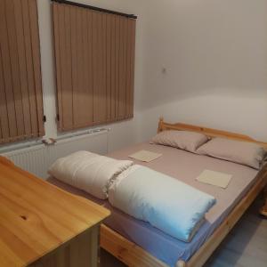 Guest Rooms Didka في كوبريفشتيتسا: سرير عليه وسادتين في غرفة