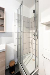 La salle de bains est pourvue d'une douche et d'une porte en verre. dans l'établissement Appart T2 proche commerces et NAVAL GROUP, à Cherbourg en Cotentin