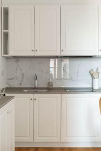 Una cocina blanca con gabinetes blancos y un fregadero. en La Vacanza Bellagio, en Bellagio