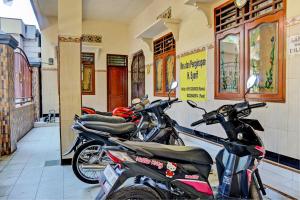 uma fila de motocicletas estacionadas num edifício em OYO 93107 Homestay H Syarif Syariah – Bandar Gresik em Gresik