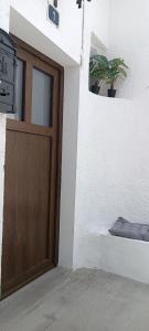a wooden door in a white building with a potted plant at Casas Rurales Complejo AIRES DEL JÚCAR in Alcalá del Júcar